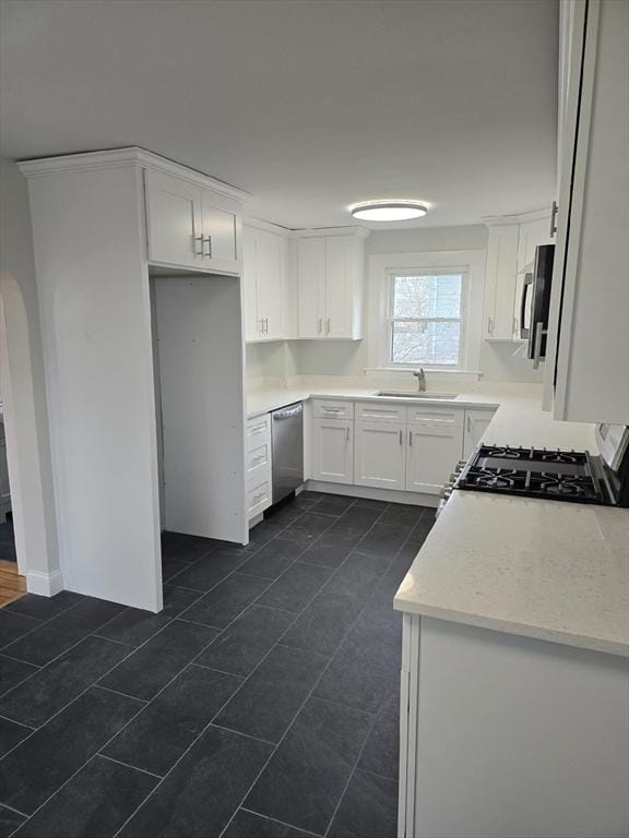 kitchen with sink, white cabinetry, and stainless steel appliances