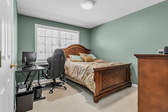 bedroom with light colored carpet and a textured ceiling