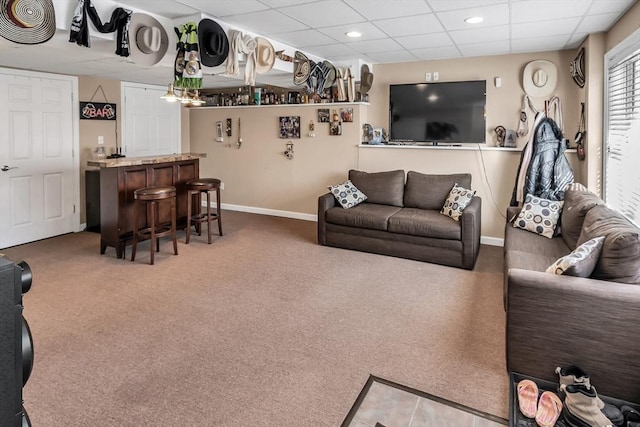 living room featuring a paneled ceiling, bar area, and carpet