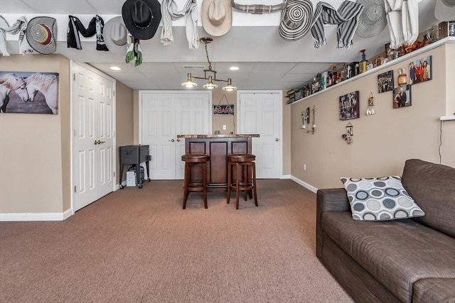 interior space featuring a paneled ceiling and dark colored carpet