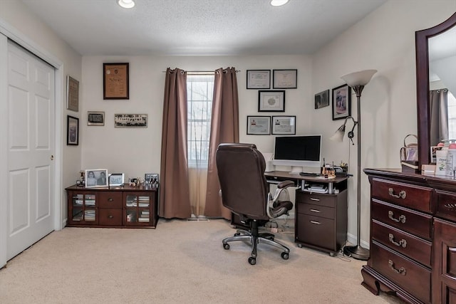 carpeted home office featuring a textured ceiling