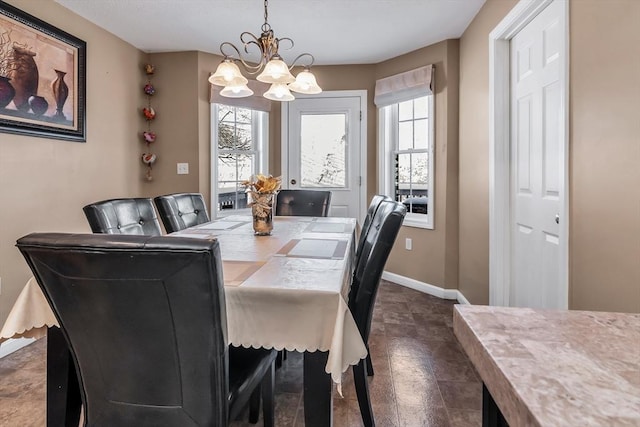 dining space with a wealth of natural light and a notable chandelier