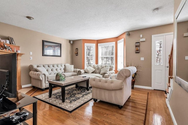 living room featuring light hardwood / wood-style floors and a textured ceiling