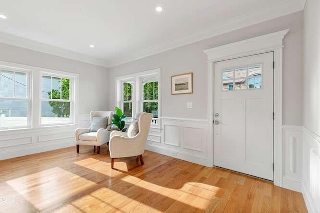 162 Swanton St Unit 162, Winchester, MA 01890 - entrance foyer featuring a decorative wall, plenty of natural light, light wood finished floors, ornamental molding, and wainscoting