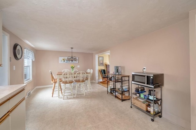 208 Green St, Weymouth, MA 02191 - dining space featuring a chandelier and baseboards
