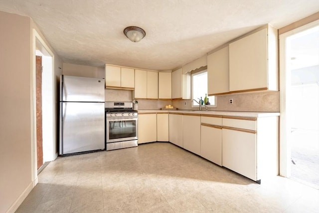 208 Green St, Weymouth, MA 02191 - kitchen with appliances with stainless steel finishes, cream cabinets, light countertops, and a sink