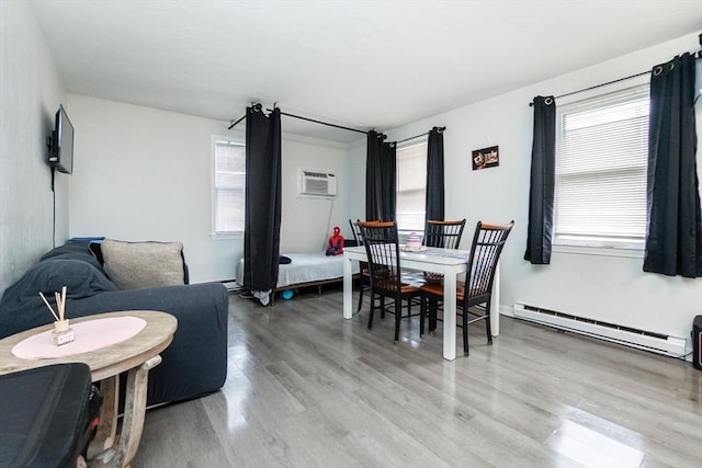 dining space featuring light wood-style flooring, baseboard heating, and a wall mounted AC