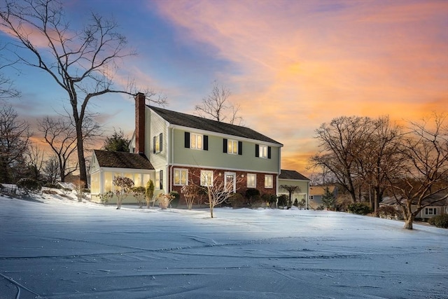 view of front of home with brick siding and a chimney