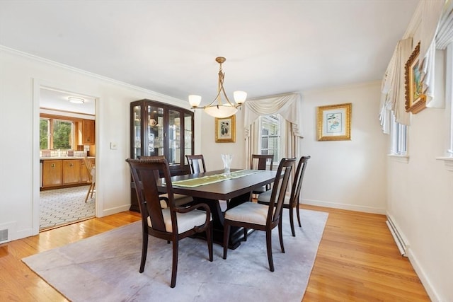 dining room featuring a notable chandelier, visible vents, ornamental molding, light wood-type flooring, and baseboards