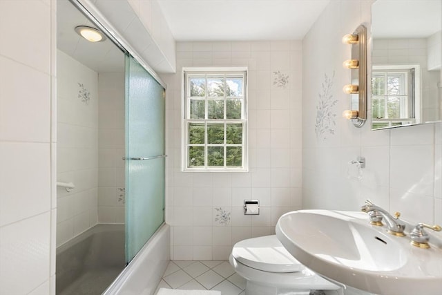 full bath with toilet, enclosed tub / shower combo, tile patterned floors, a sink, and tile walls