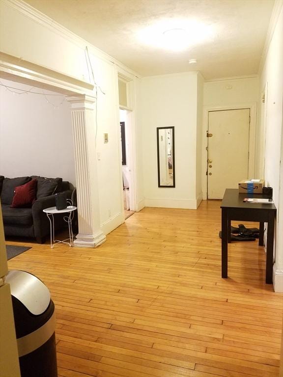 interior space featuring crown molding and light hardwood / wood-style floors