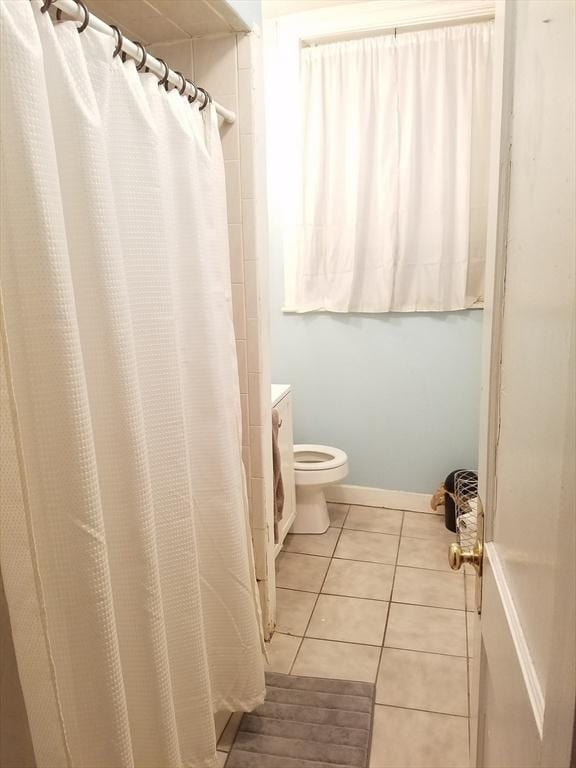 bathroom with tile patterned flooring, a shower with shower curtain, and toilet