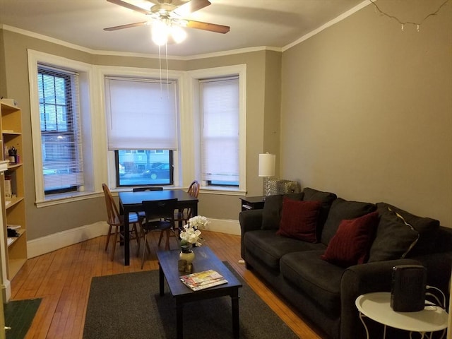 living room featuring hardwood / wood-style floors, a wealth of natural light, ornamental molding, and ceiling fan