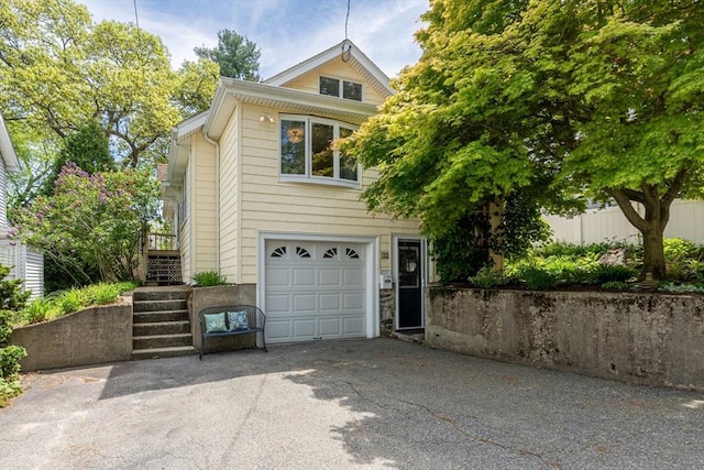 view of front of property featuring driveway, stairway, an attached garage, and fence