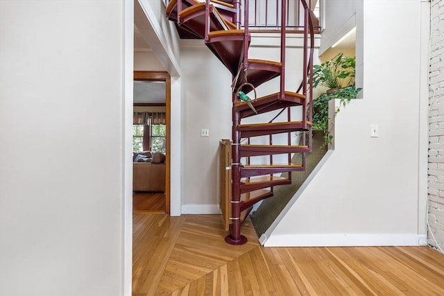 staircase featuring baseboards and wood-type flooring