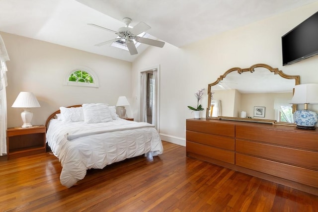 bedroom featuring vaulted ceiling, wood finished floors, baseboards, and ceiling fan