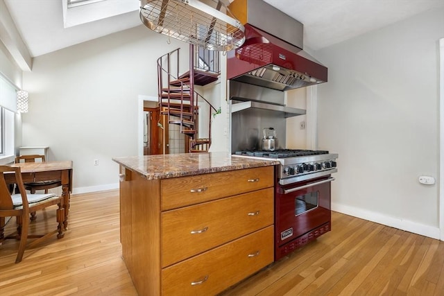 kitchen with designer stove, exhaust hood, light wood-style flooring, and baseboards