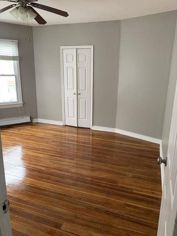 58 Ames Ave, Chicopee, MA 01013 - empty room with baseboard heating, ceiling fan, hardwood / wood-style floors, and baseboards