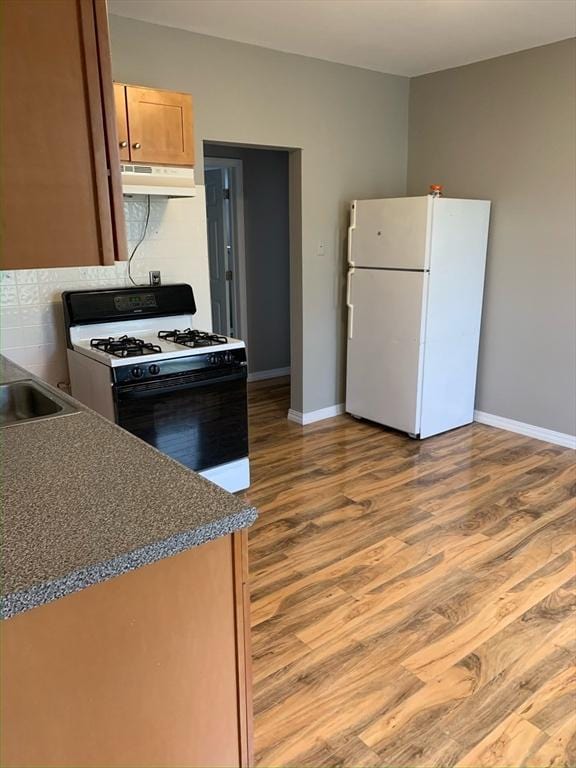 58 Ames Ave, Chicopee, MA 01013 - kitchen featuring freestanding refrigerator, gas range, under cabinet range hood, and wood finished floors