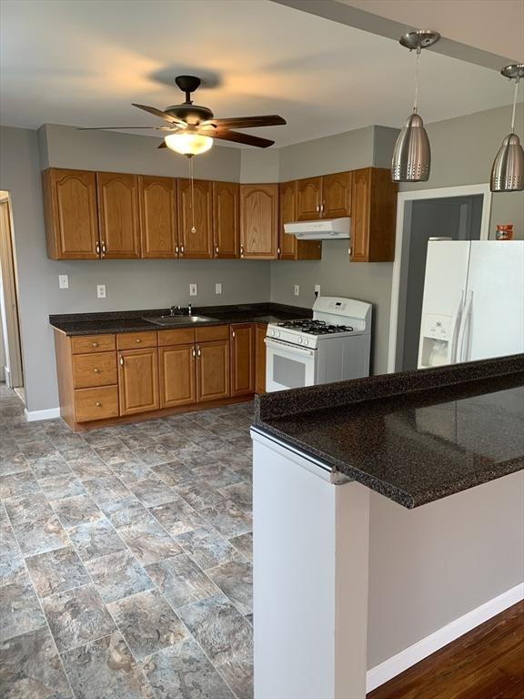 58 Ames Ave, Chicopee, MA 01013 - kitchen featuring white appliances, under cabinet range hood, brown cabinets, ceiling fan, and baseboards