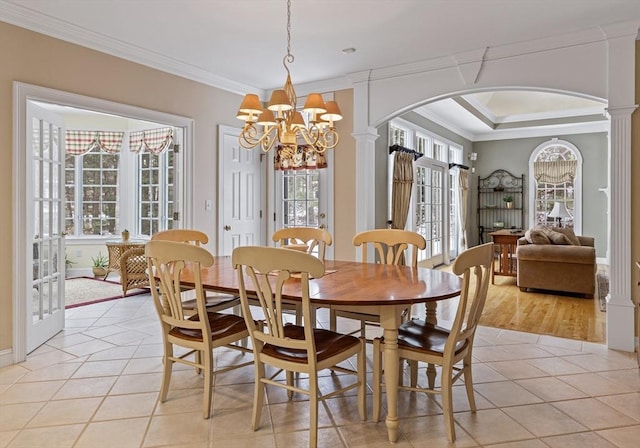 dining space with ornate columns, ornamental molding, and light tile patterned floors