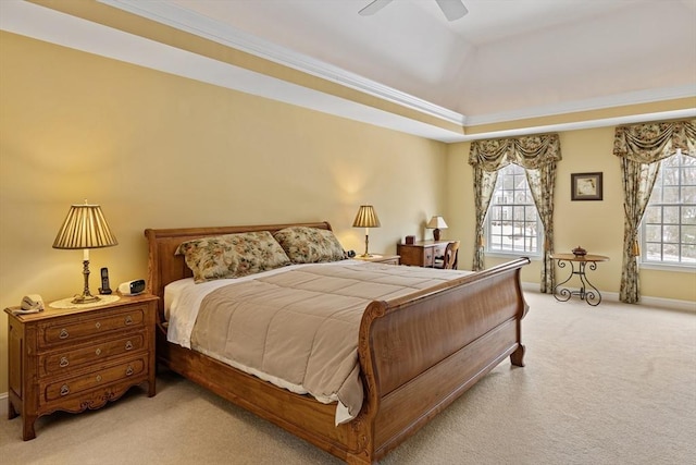 bedroom with ornamental molding, ceiling fan, a tray ceiling, and light carpet