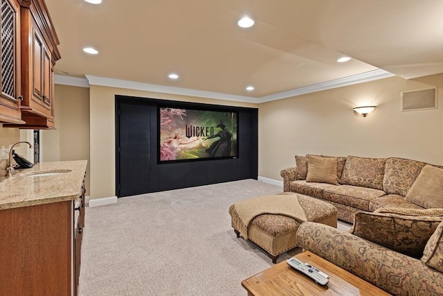 cinema featuring sink, crown molding, and light colored carpet