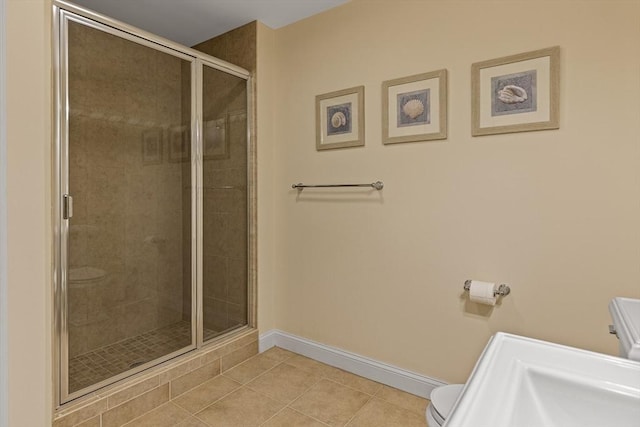 bathroom with toilet, an enclosed shower, and tile patterned floors