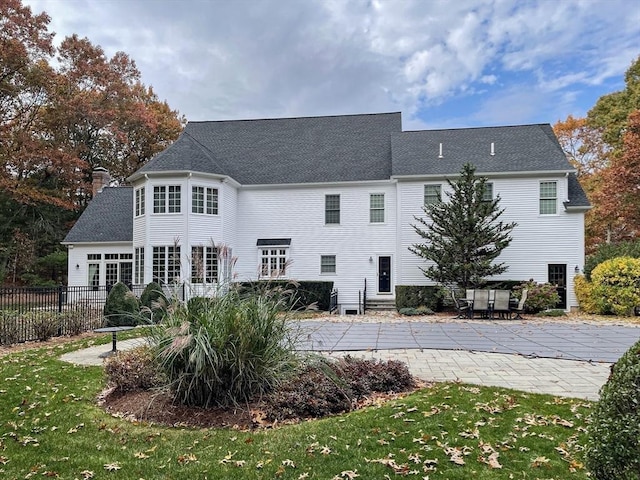 back of property featuring a lawn and a patio