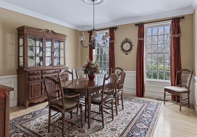 dining area featuring a notable chandelier, light hardwood / wood-style flooring, and ornamental molding