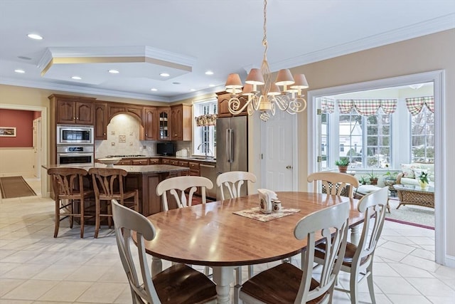 tiled dining space with sink, an inviting chandelier, and crown molding