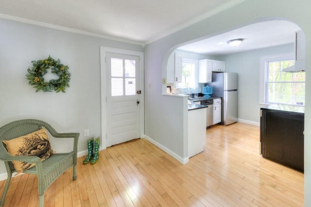 197 Eastern Ave, Worcester, MA 01605 - entryway with arched walkways, light wood-style floors, baseboards, plenty of natural light, and crown molding