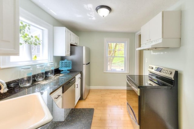 197 Eastern Ave, Worcester, MA 01605 - kitchen with stainless steel appliances, a sink, under cabinet range hood, and dark countertops