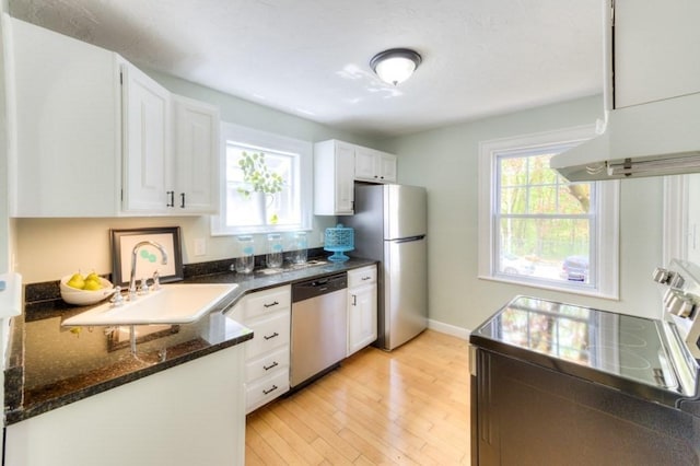 197 Eastern Ave, Worcester, MA 01605 - kitchen with stainless steel appliances, a sink, white cabinetry, light wood-style floors, and dark stone countertops