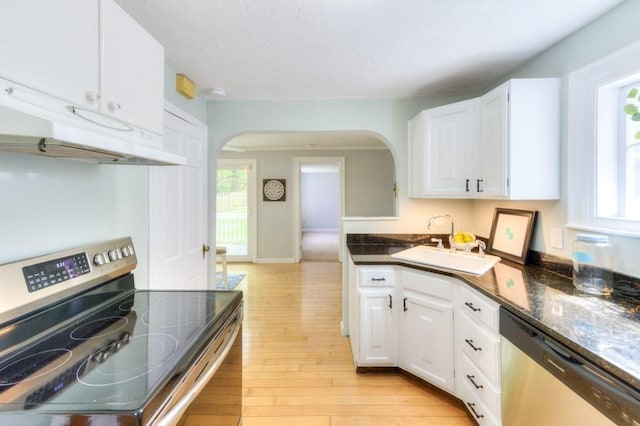 197 Eastern Ave, Worcester, MA 01605 - kitchen featuring appliances with stainless steel finishes, a sink, arched walkways, light wood-type flooring, and white cabinetry