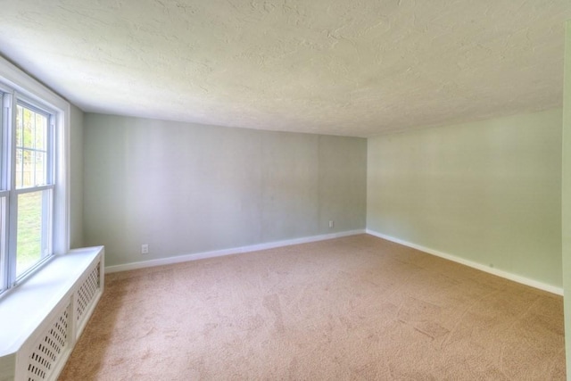 197 Eastern Ave, Worcester, MA 01605 - unfurnished room featuring light carpet, a textured ceiling, baseboards, and radiator