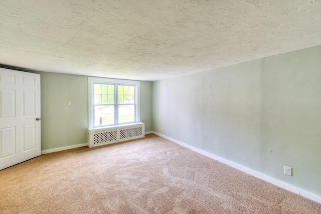 197 Eastern Ave, Worcester, MA 01605 - spare room featuring radiator heating unit, carpet flooring, a textured ceiling, and baseboards