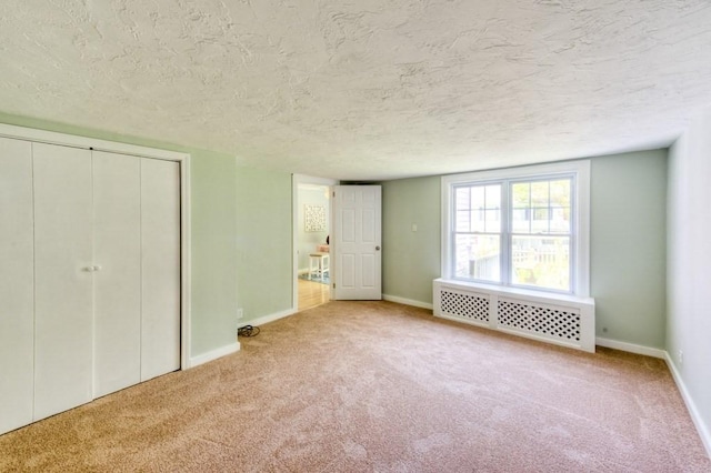 197 Eastern Ave, Worcester, MA 01605 - unfurnished bedroom featuring radiator, carpet, a textured ceiling, and baseboards