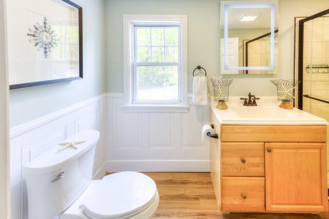197 Eastern Ave, Worcester, MA 01605 - full bathroom featuring a wainscoted wall, toilet, vanity, a decorative wall, and wood finished floors