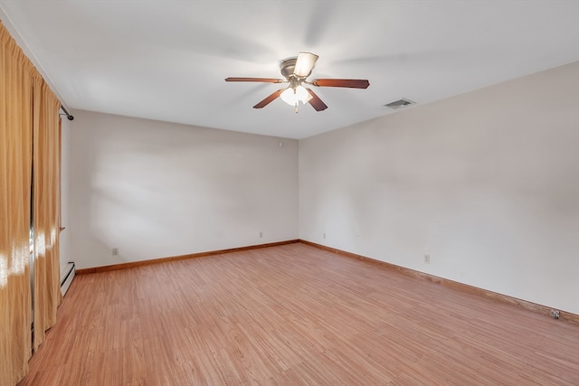 empty room with ceiling fan, light hardwood / wood-style flooring, and a baseboard heating unit