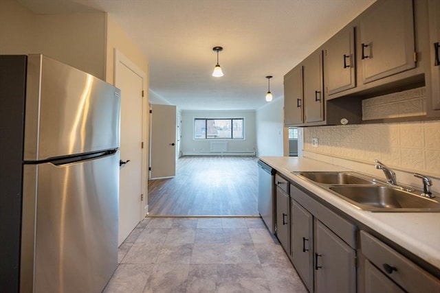 kitchen with decorative light fixtures, decorative backsplash, appliances with stainless steel finishes, and sink