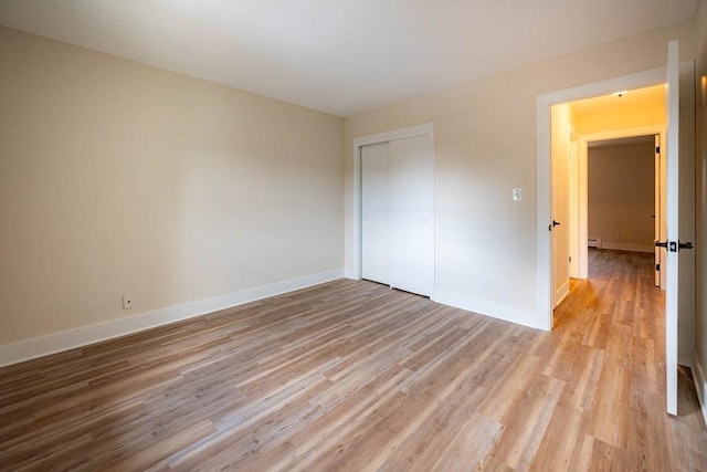 unfurnished bedroom featuring a closet and light hardwood / wood-style flooring