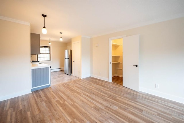 unfurnished living room with light wood-type flooring and baseboard heating