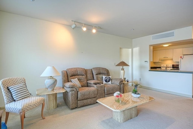 carpeted living room featuring rail lighting