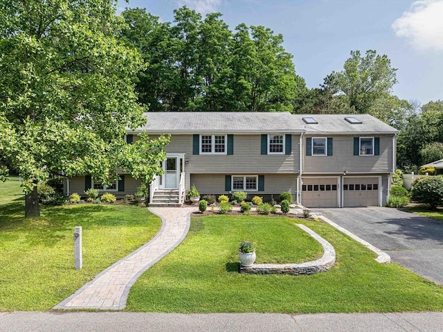 32 Eaton Rd W, Framingham, MA 01701 - raised ranch featuring asphalt driveway, an attached garage, and a front yard