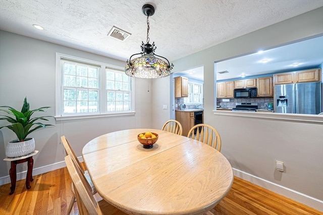 32 Eaton Rd W, Framingham, MA 01701 - dining area with light wood-style flooring and a textured ceiling