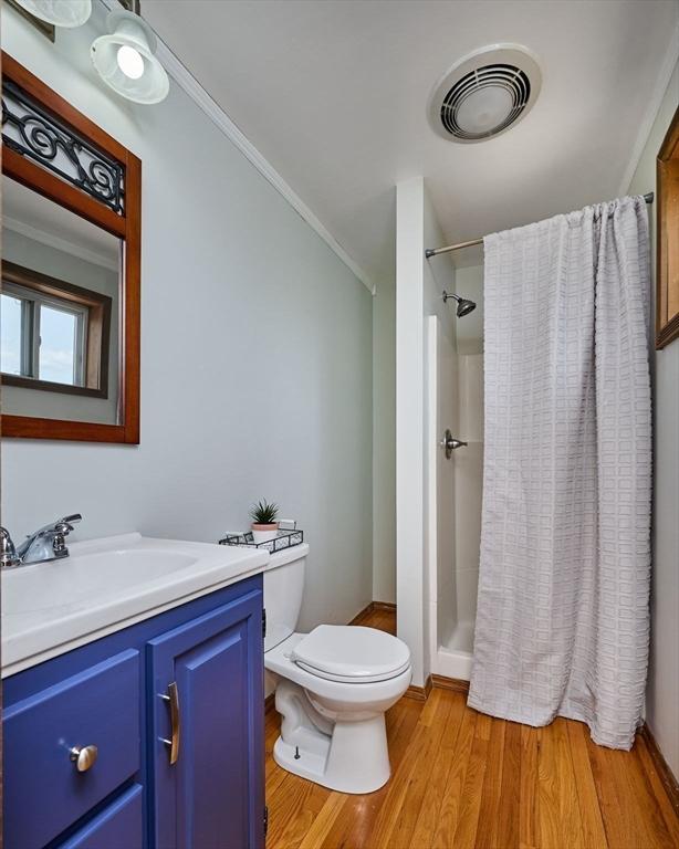 18 Coombs Hill Rd, Colrain, MA 01340 - bathroom featuring toilet, vanity, wood finished floors, a stall shower, and crown molding