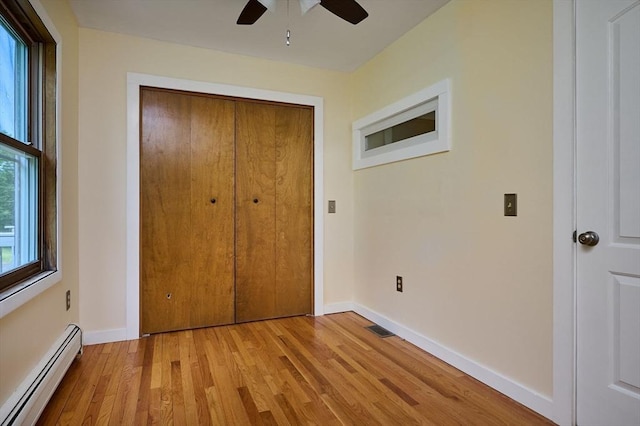 18 Coombs Hill Rd, Colrain, MA 01340 - unfurnished bedroom with baseboard heating, light wood-style floors, a closet, and baseboards