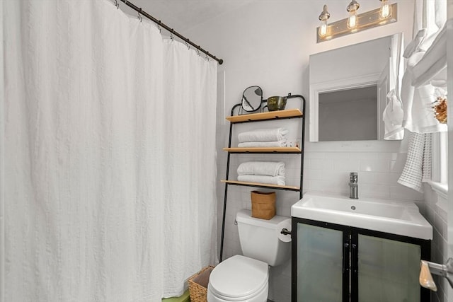 full bath with toilet, tile walls, and vanity