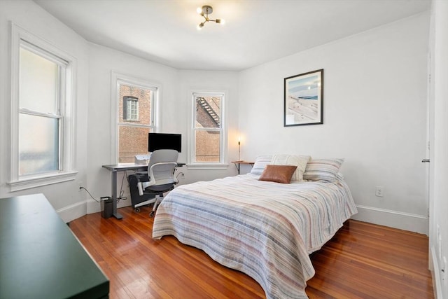 bedroom with baseboards and wood finished floors